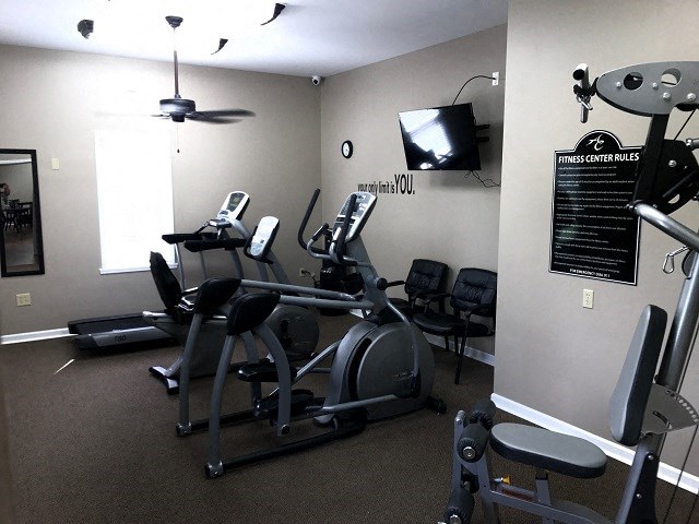 a gym with some machines and a tv in it