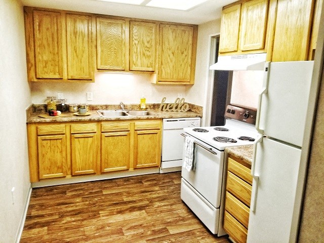 a small kitchen with a white stove and refrigerator