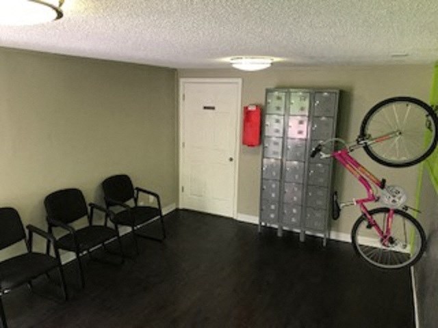 a bike hanging on the wall in a room with chairs