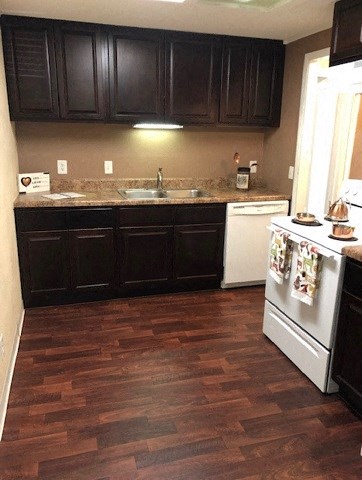 a kitchen with wooden floors and black cabinets