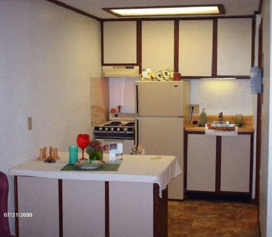 a kitchen with a white counter and a refrigerator
