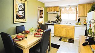 A dining table with chairs and a framed picture on the wall.