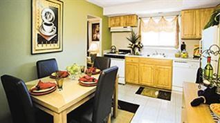 A dining table with chairs and a framed picture on the wall.