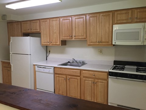 A kitchen with wooden cabinets and white appliances.