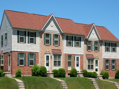A row of houses with green shutters.