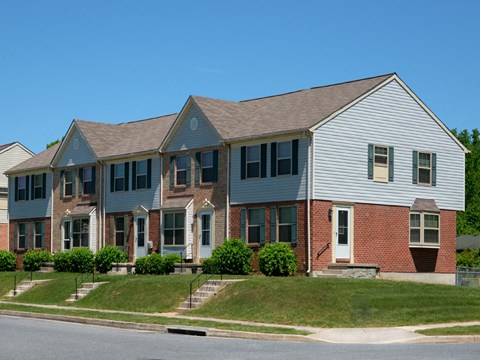 A row of houses with a blue sky in the background.