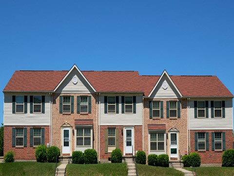 A two story house with a red roof and white siding.