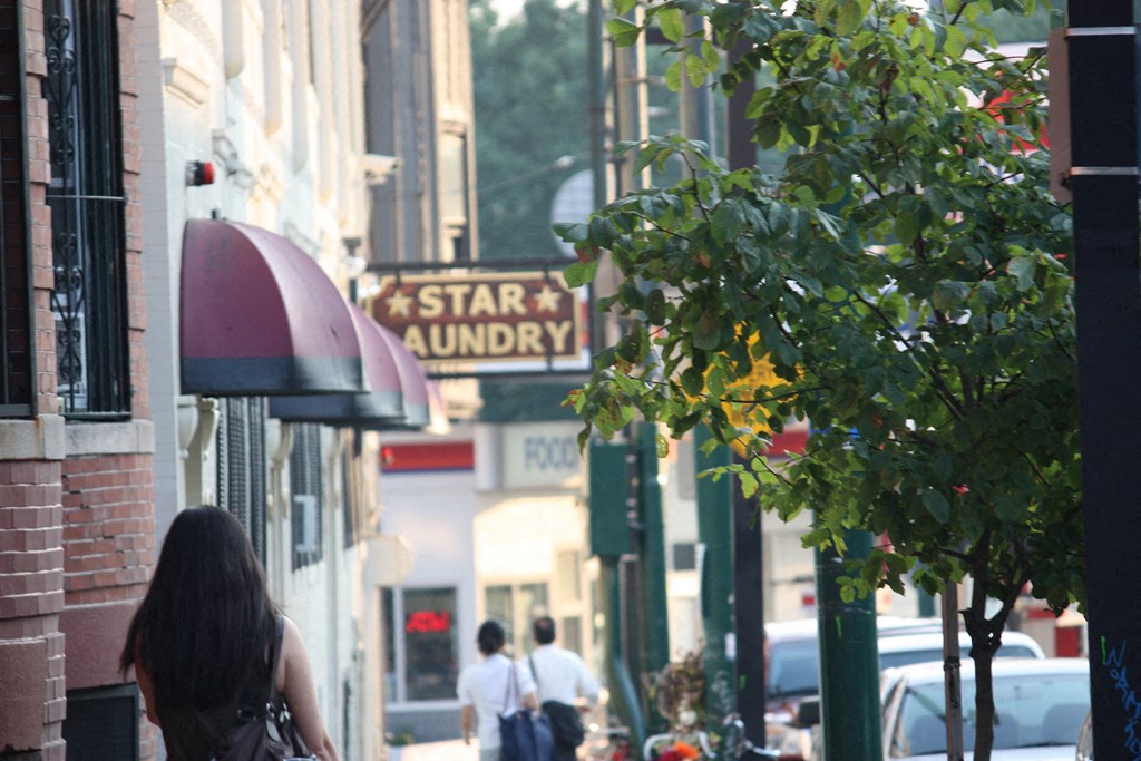 a city street with people walking and a sign for star laundry
