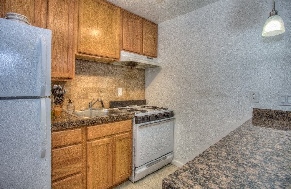 a kitchen with a stove refrigerator and sink