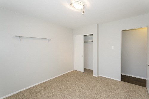 an empty room with a closet and a door to a bathroom
