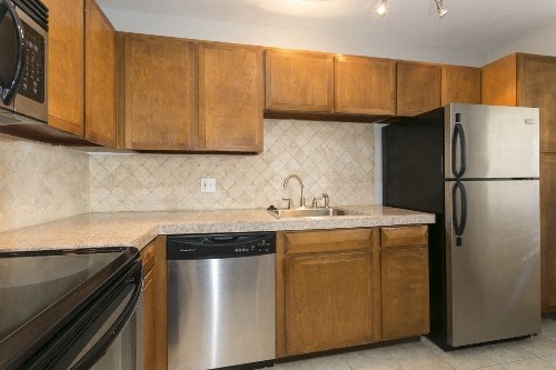 a kitchen with stainless steel appliances and wooden cabinets