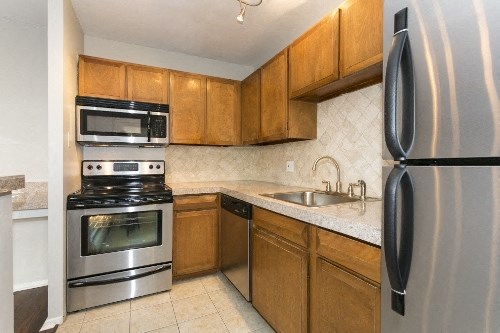 a kitchen with stainless steel appliances and wooden cabinets