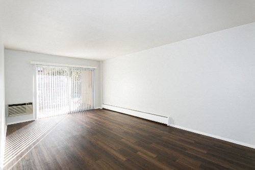 an empty living room with white walls and wood floors