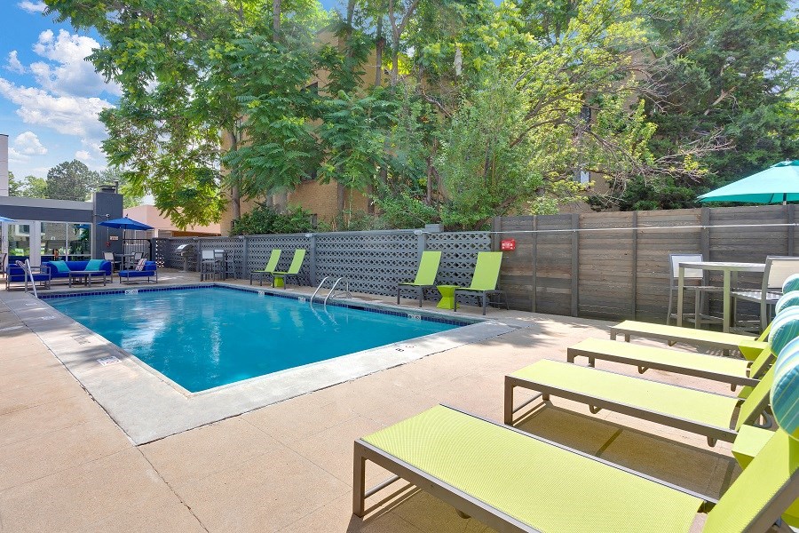 a swimming pool with lounge chairs and umbrellas