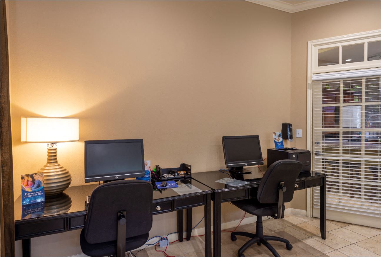 a home office with two desks and two computer monitors