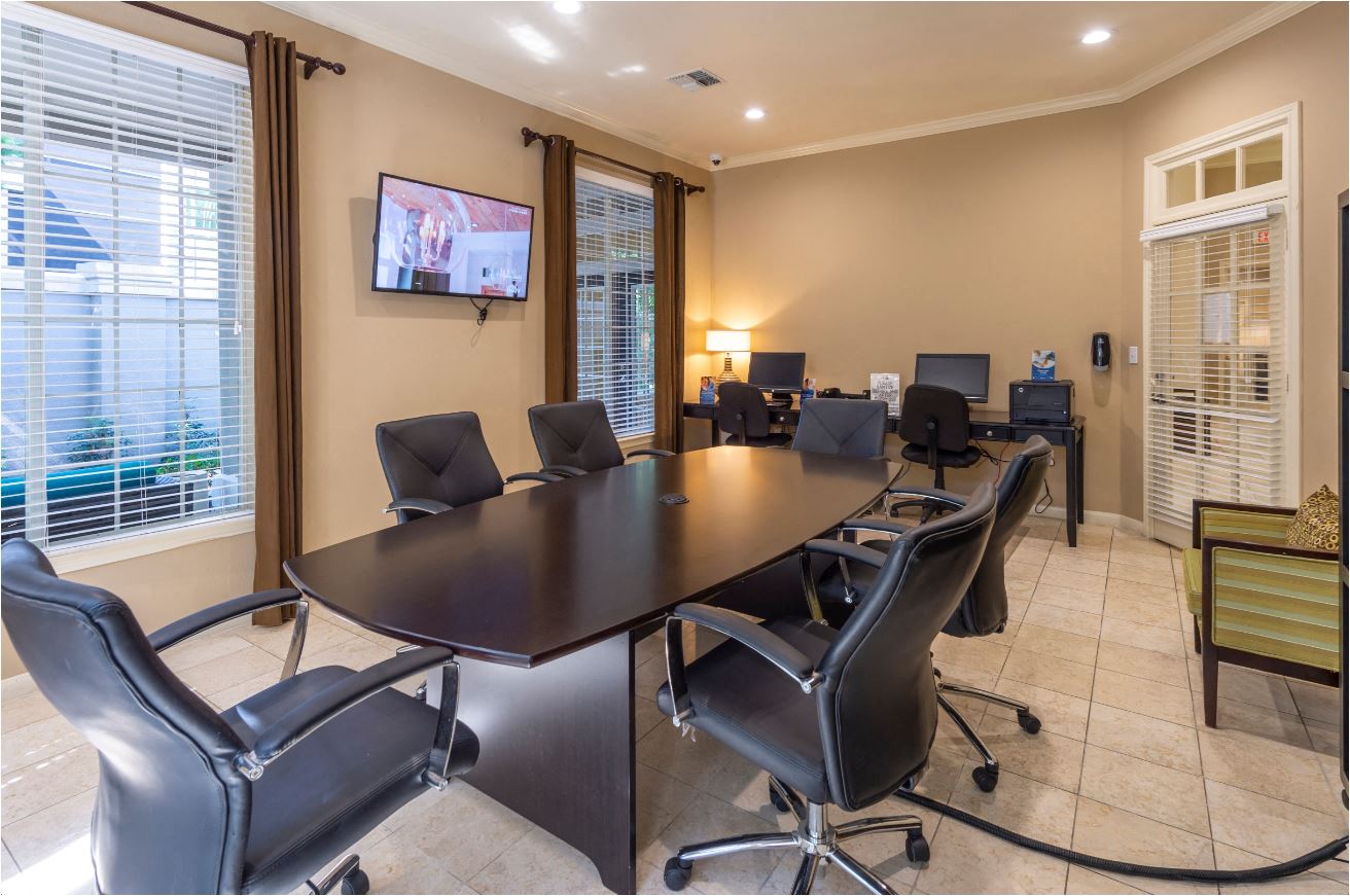 a conference room with a large table and chairs and a tv