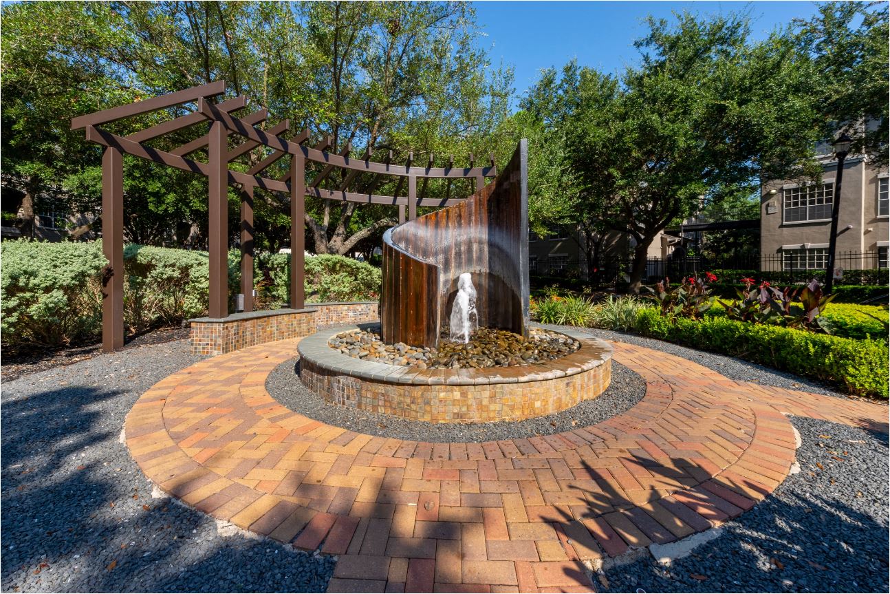 a fountain sits in the middle of a brick patio