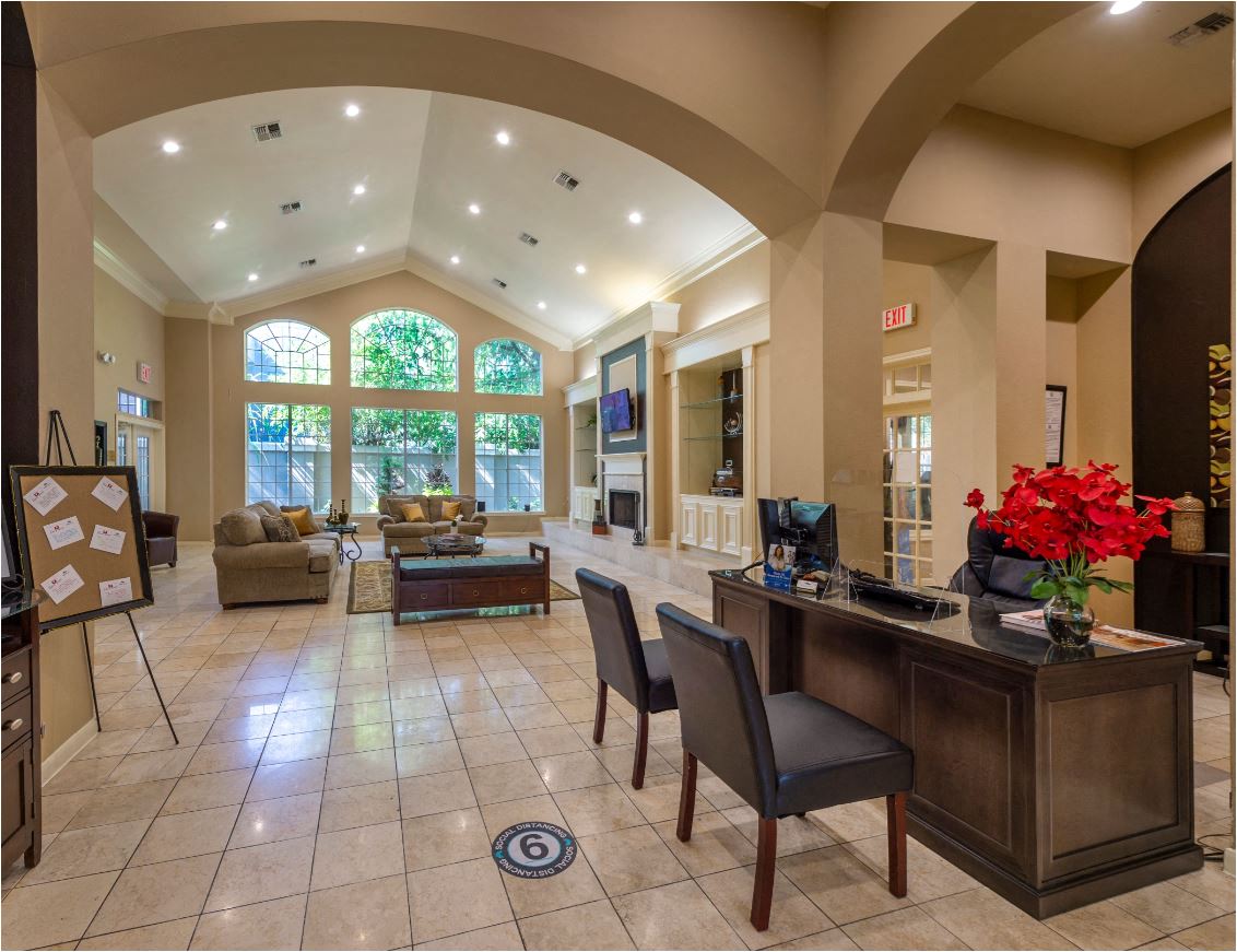 a lobby with a reception desk and a living room