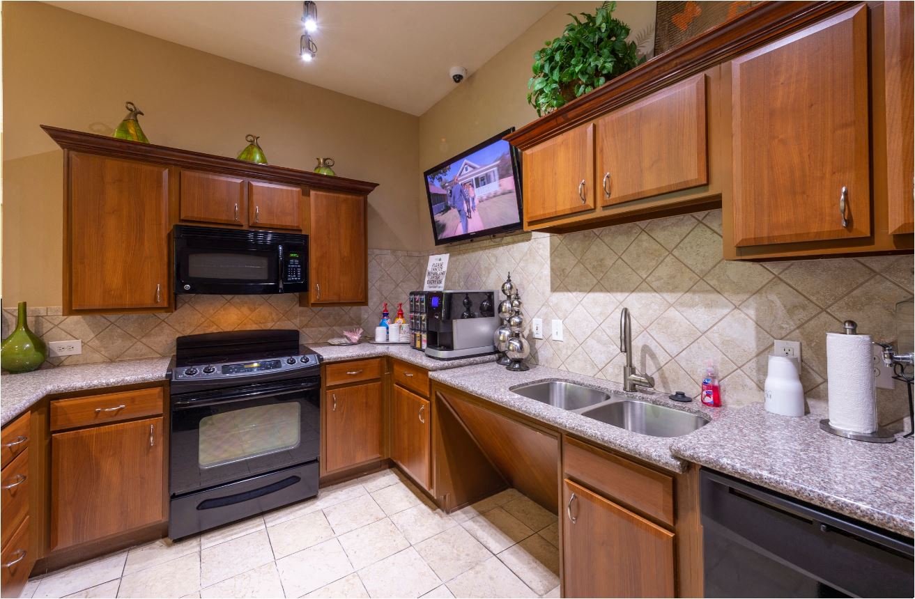 a kitchen with wooden cabinets and a sink and a stove