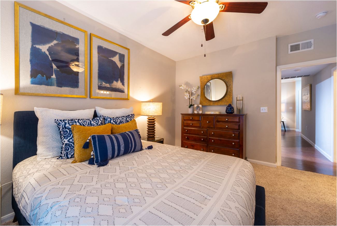 a bedroom with a large bed and a ceiling fan