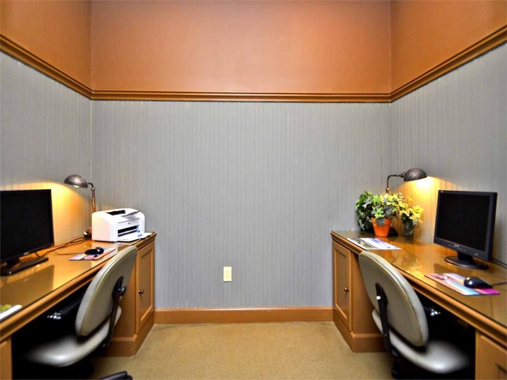a home office with two desks and two computer monitors