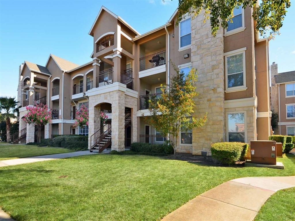 an apartment building with a lawn in front of it