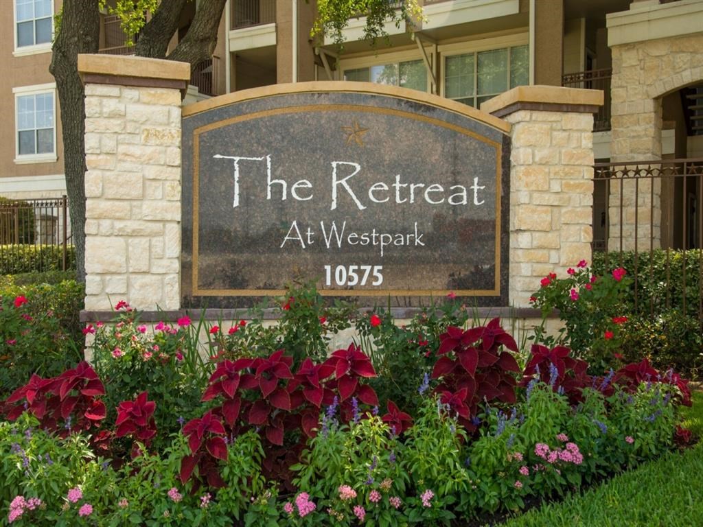 the retreat sign with flowers in front of a building