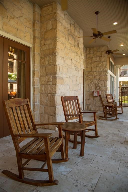 a group of wooden rocking chairs on a porch