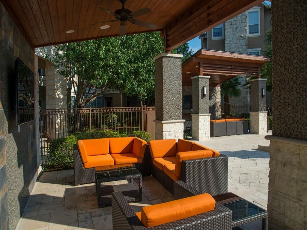 a covered patio with couches and a table