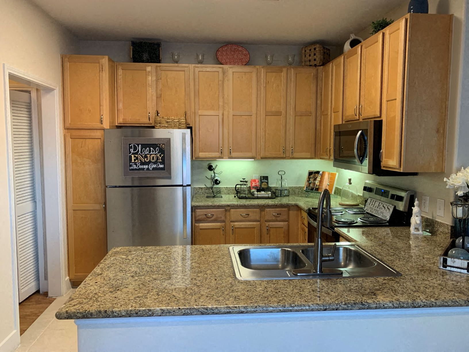 a kitchen with a granite counter top and a stainless steel refrigerator