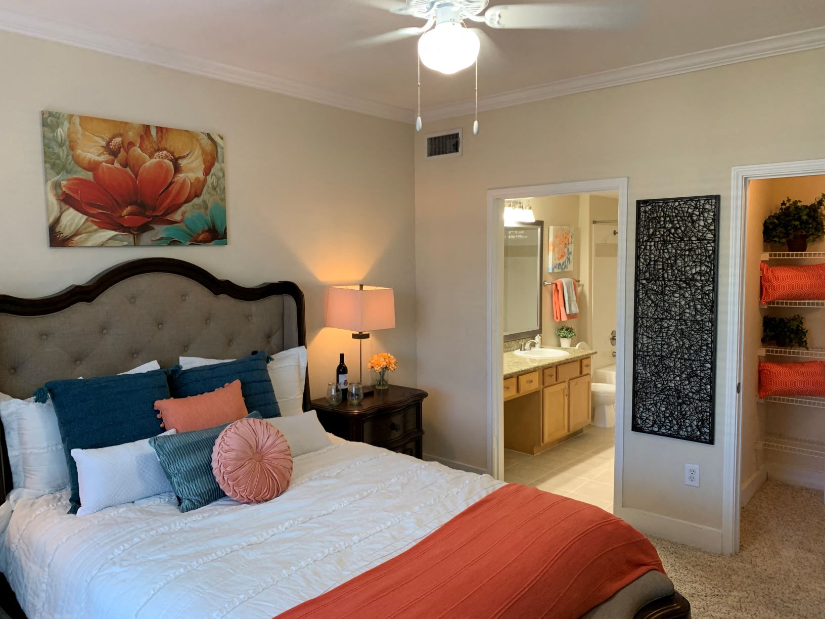 a bedroom with a large bed and a bathroom with a mirror