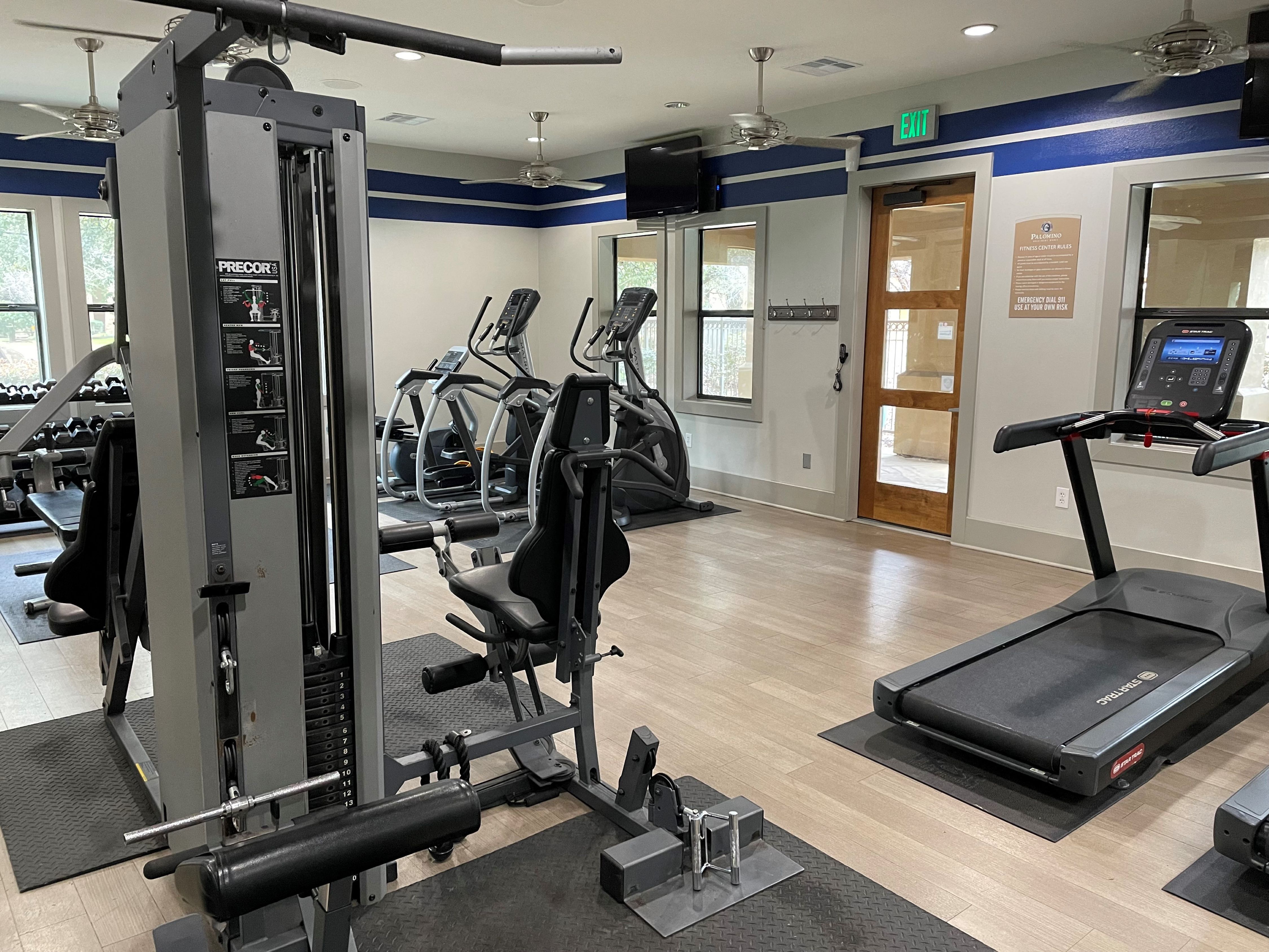 a gym with cardio equipment and weights in a wellness center