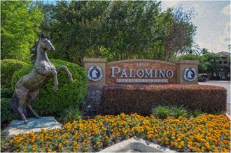 a statue of a horse in front of a palomino sign