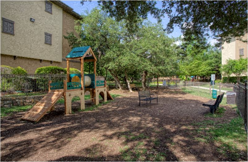 a playground with a wooden swing and a bench