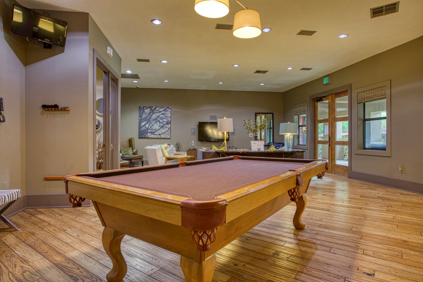 a games room with a pool table in the middle