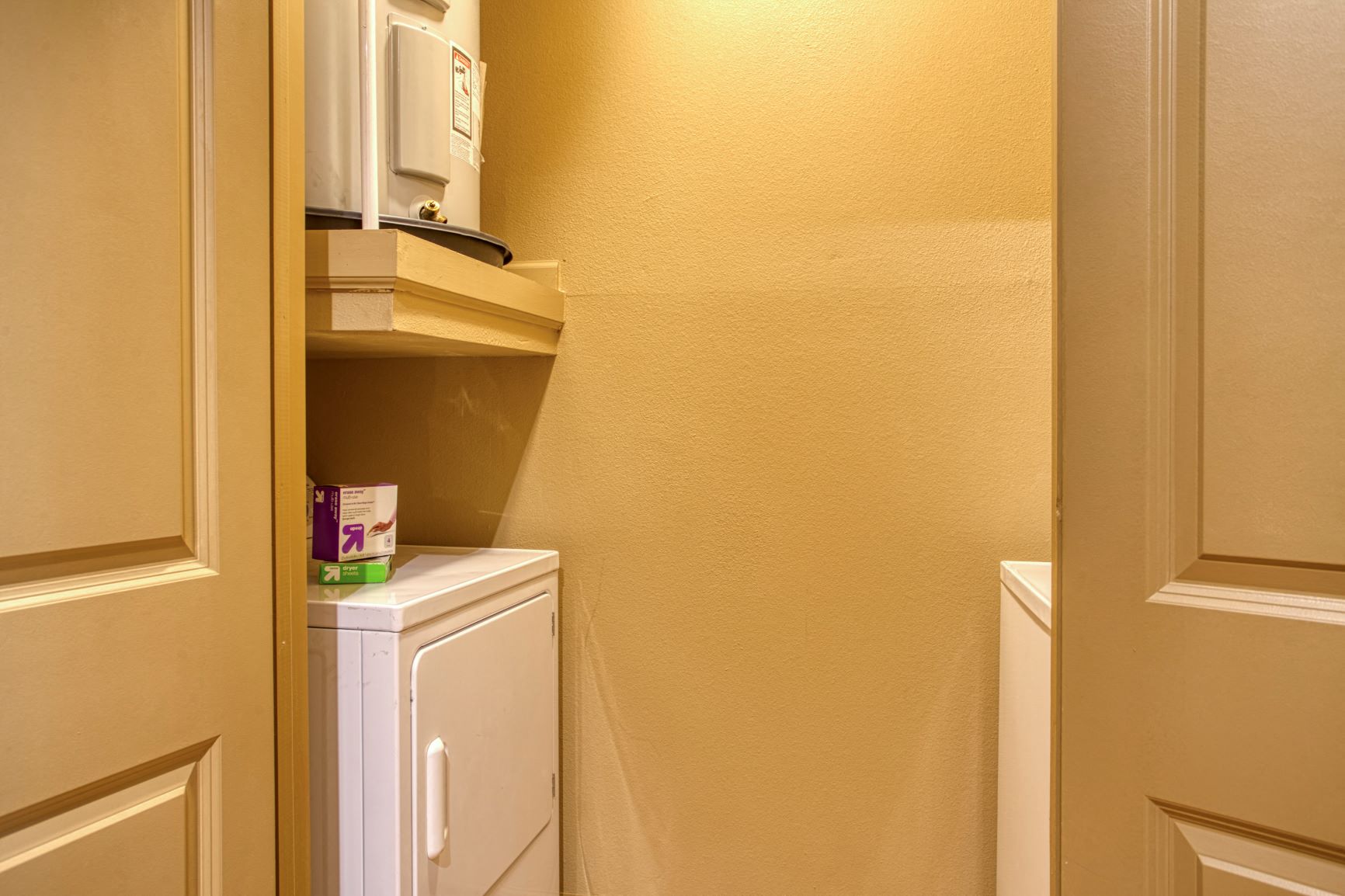 a small kitchen with a refrigerator and a door to a closet