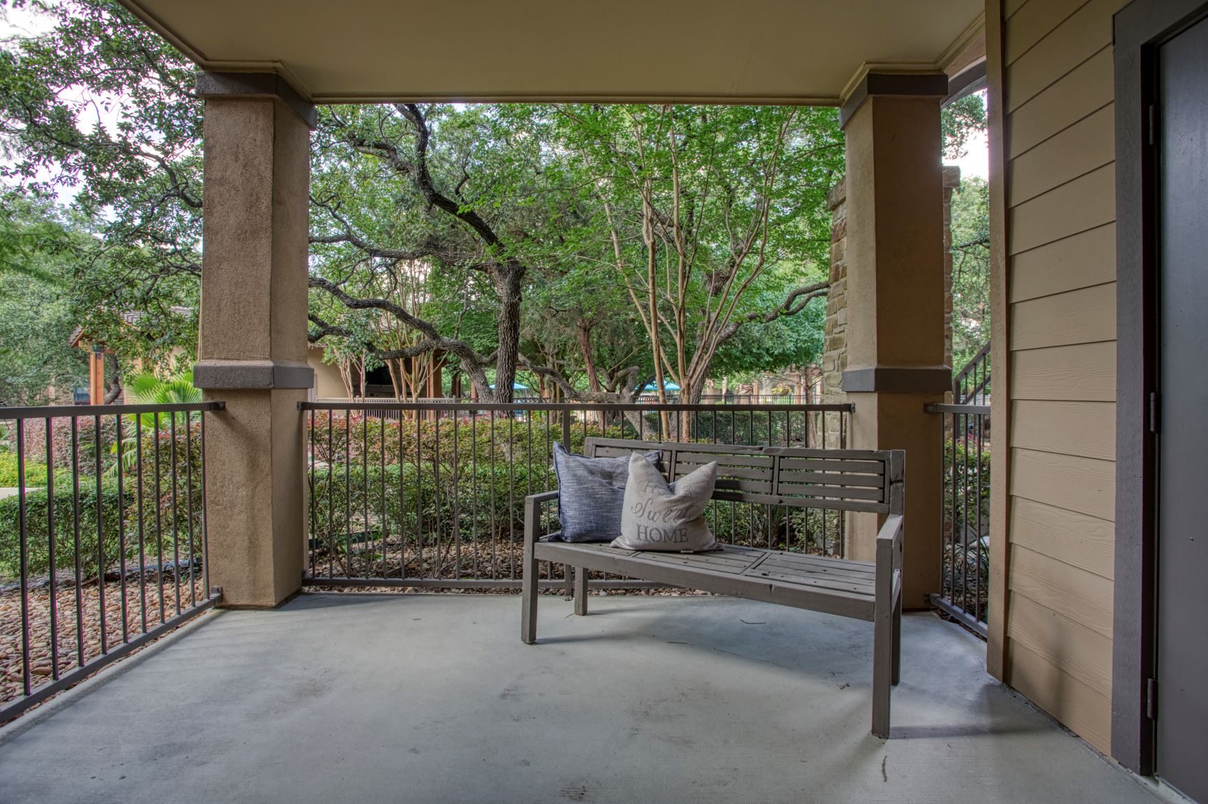 a bench on a porch with trees in the background