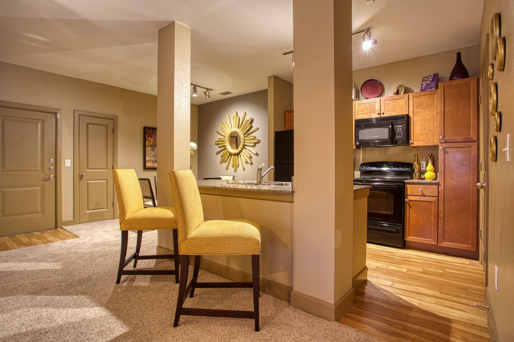 a kitchen and dining area with yellow chairs and a counter