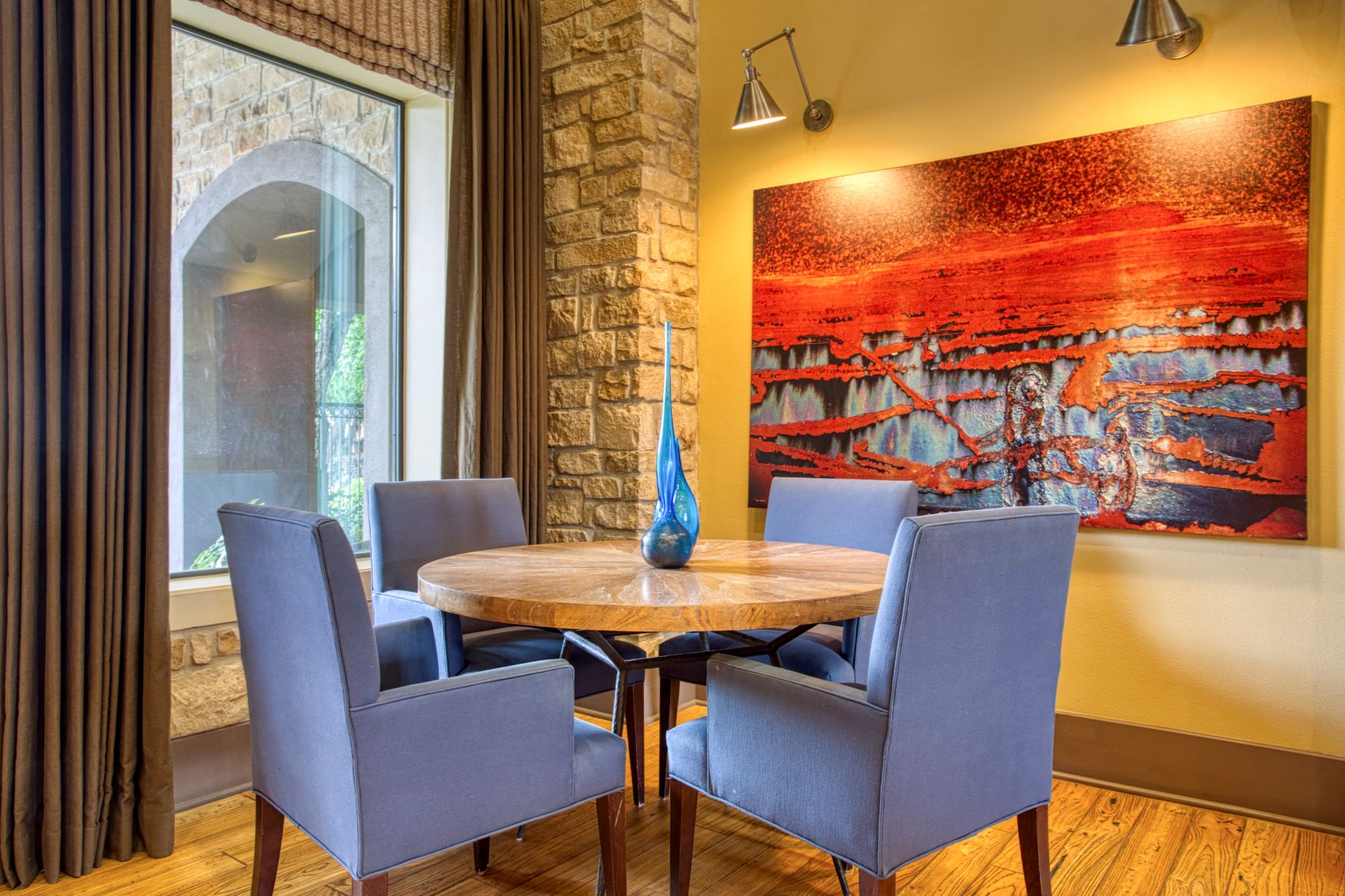 a dining room with a table and chairs and a painting on the wall