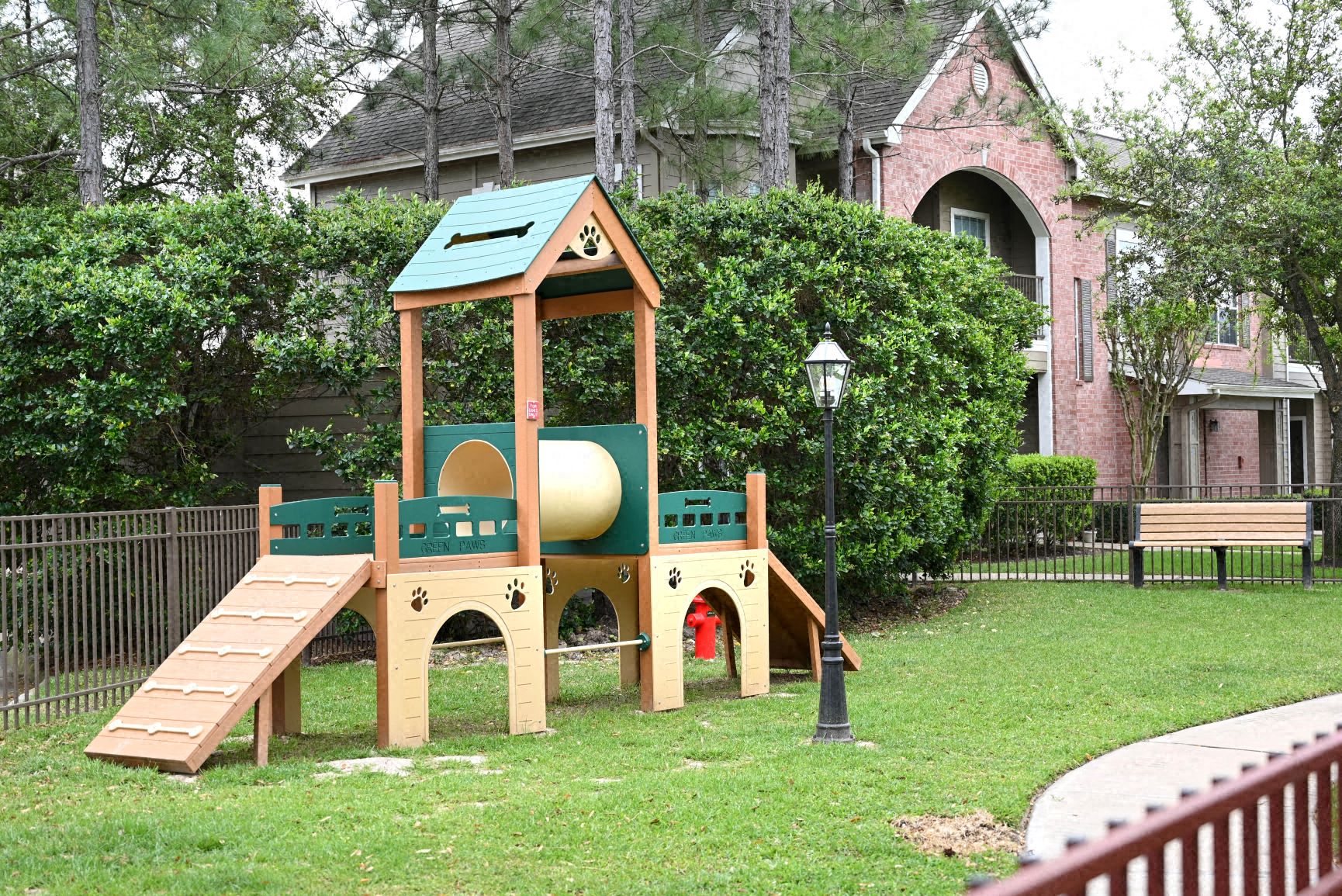 a playground with a wooden swing set and a playground ball