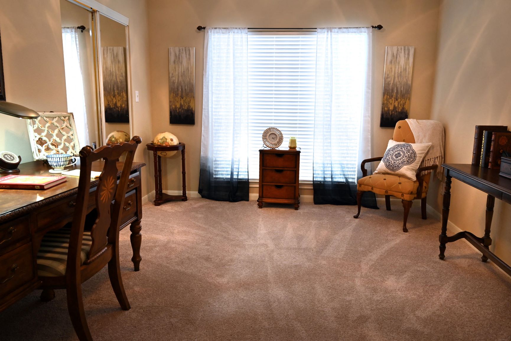 a living room with a window and a desk with a chair