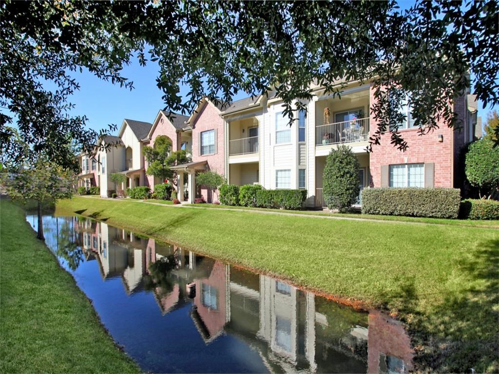 an apartment building is reflected in a pool of water