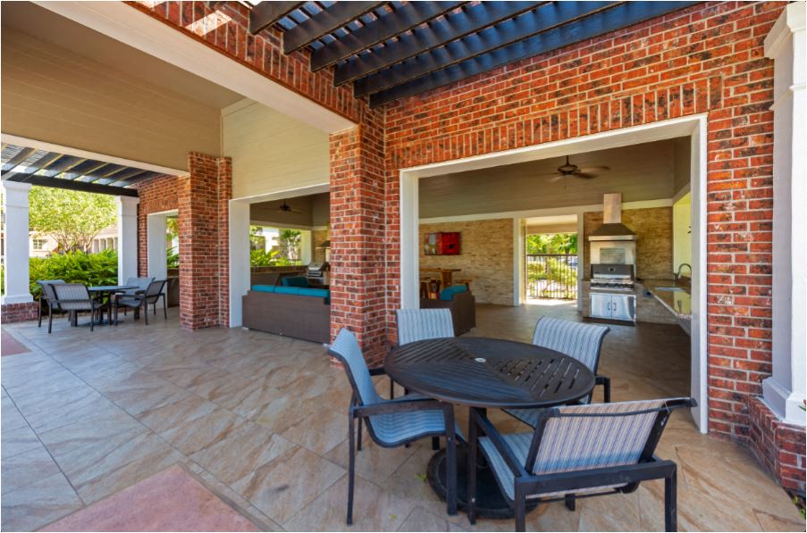 a patio with a table and chairs and a brick wall