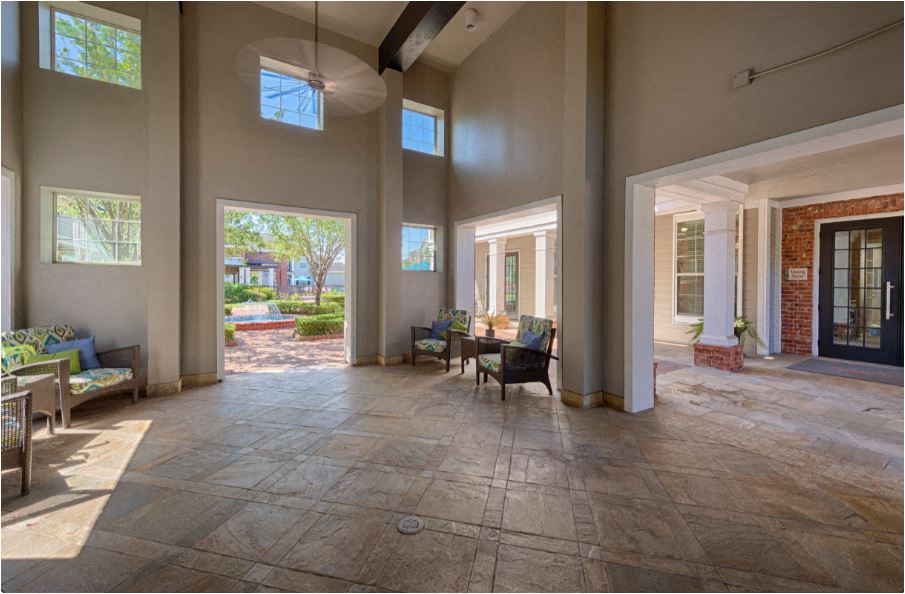 a large living room with large windows and a table and chairs