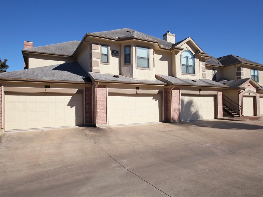 a large house with a driveway and garage doors