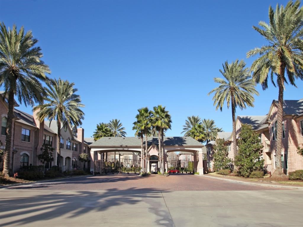 a street with palm trees in front of a building