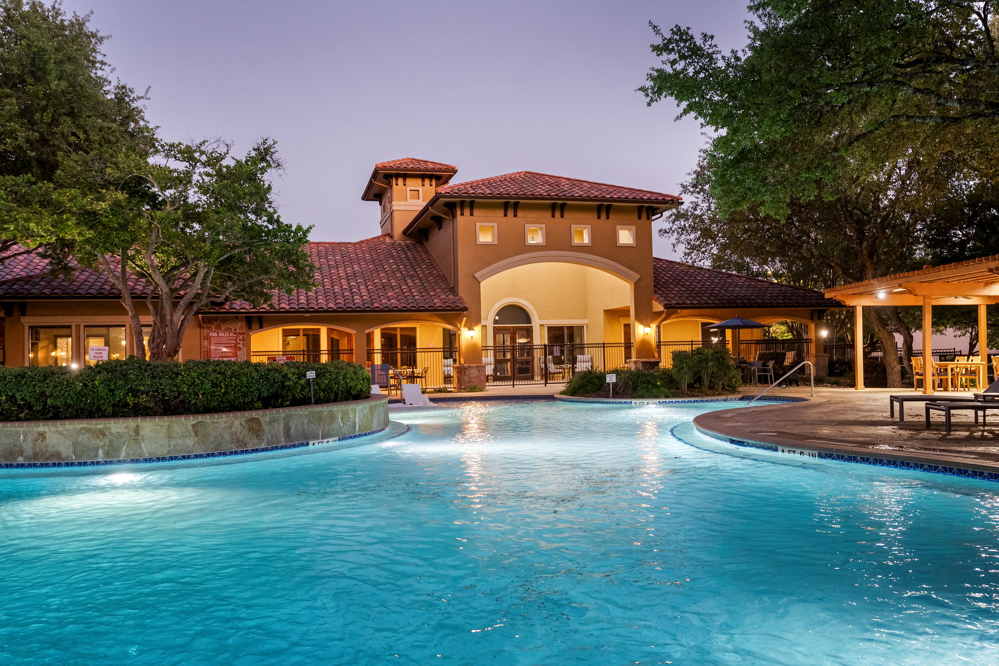 A large house with a pool in front.