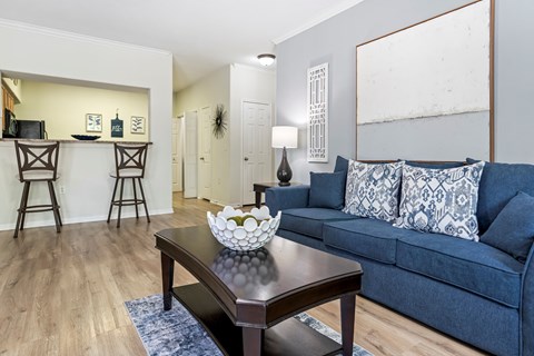 A living room with a blue couch and a wooden coffee table.
