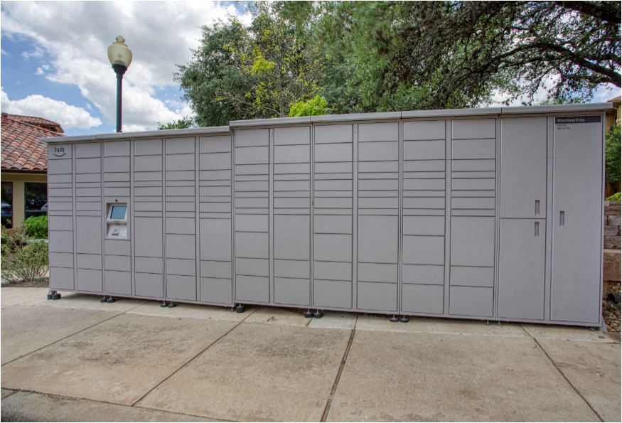 a white shed with a door on the side of a sidewalk