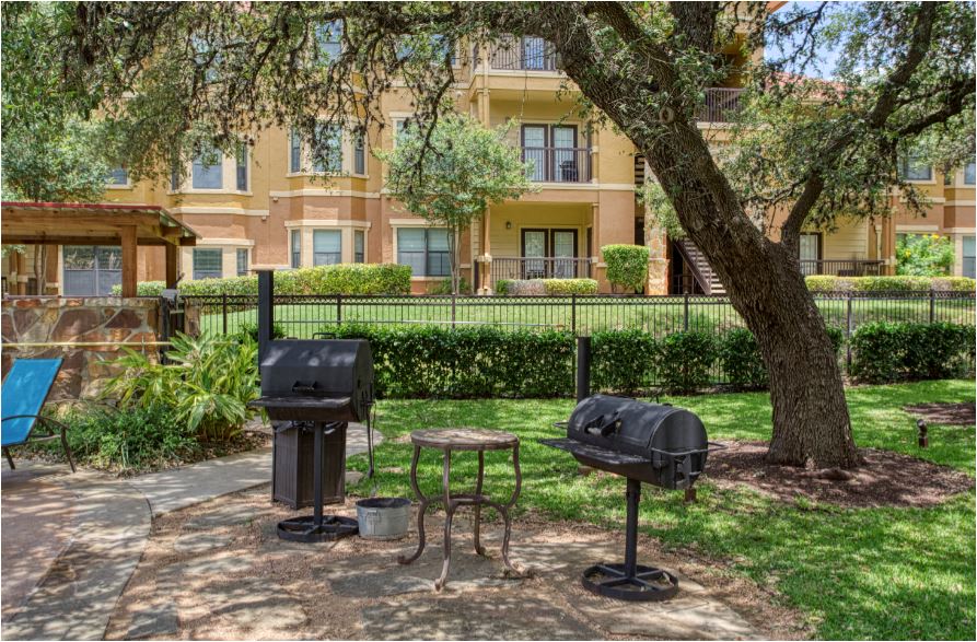 two bbq pits on a patio in front of an apartment building